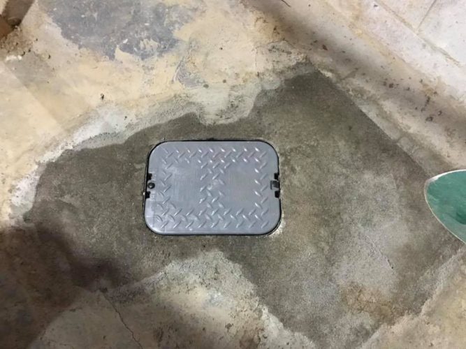 an access hatch embedded in a cement floor