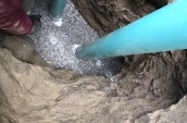 two blue pipes emerging from a hole in the ground