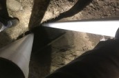 two white pipes emerging from a hole in the ground