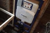 a water heater sitting on top of a wooden floor