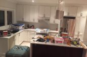 a kitchen with a lot of clutter on the counter