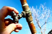 a person holding a copper pipe with a valve in their hand
