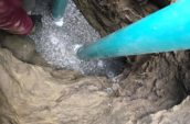 two blue pipes emerging from a hole in the ground