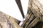 a hole in the ground with a couple of pipes emerging from another pipe