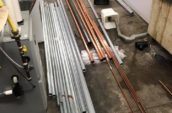 a bunch of metal pipes laid on top of a floor