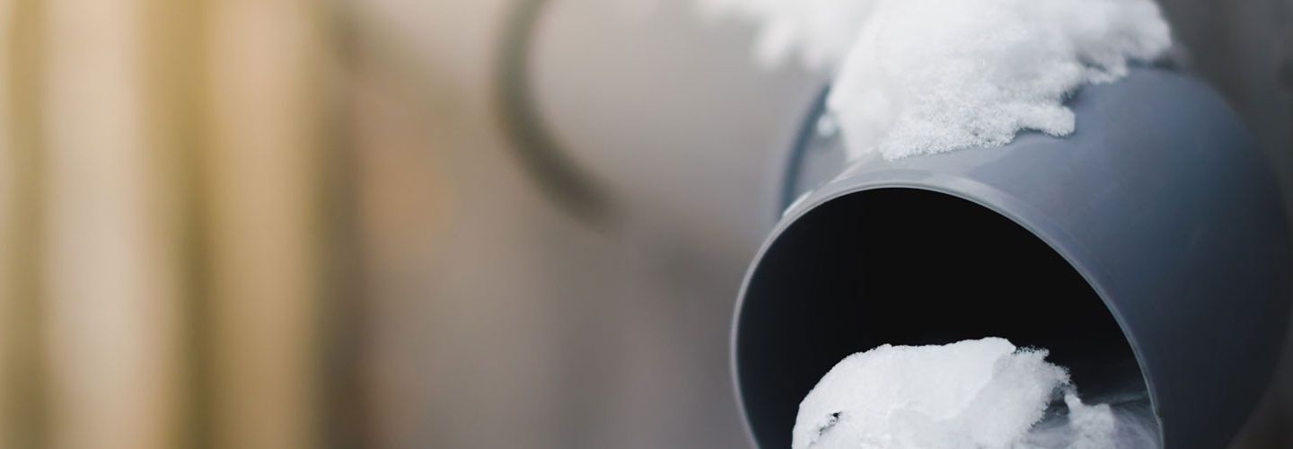 an outflow pipe partially covered with snow